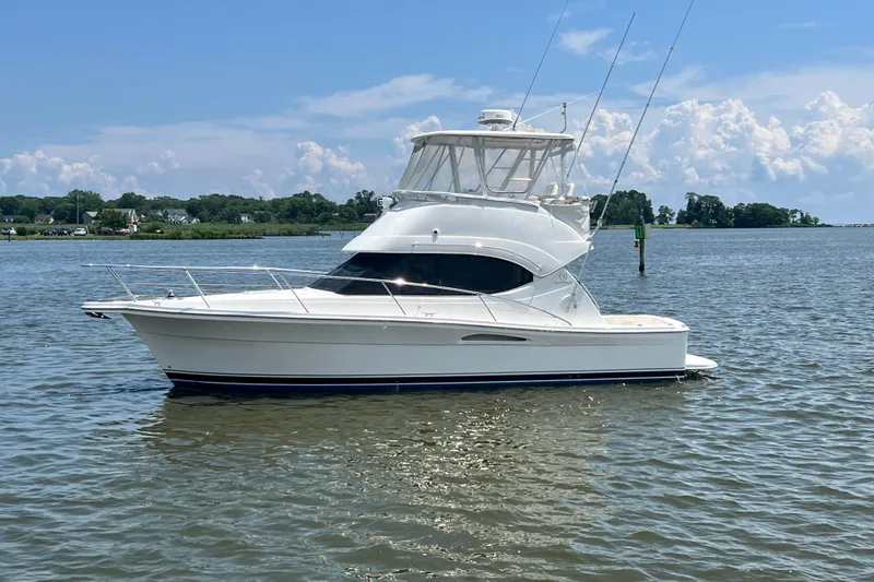 Slide: The Image of 2007 Riviera 33 Flybridge yacht on calm water under a clear sky. - 3