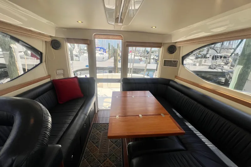Slide: The Image of Luxurious interior of 2007 Riviera 33 Flybridge yacht with elegant seating and wooden table. - 31