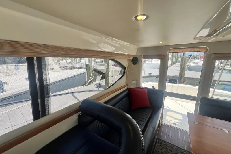 Slide: The Image of Interior of 2007 Riviera 33 Flybridge yacht with seating and table, dock view. - 33