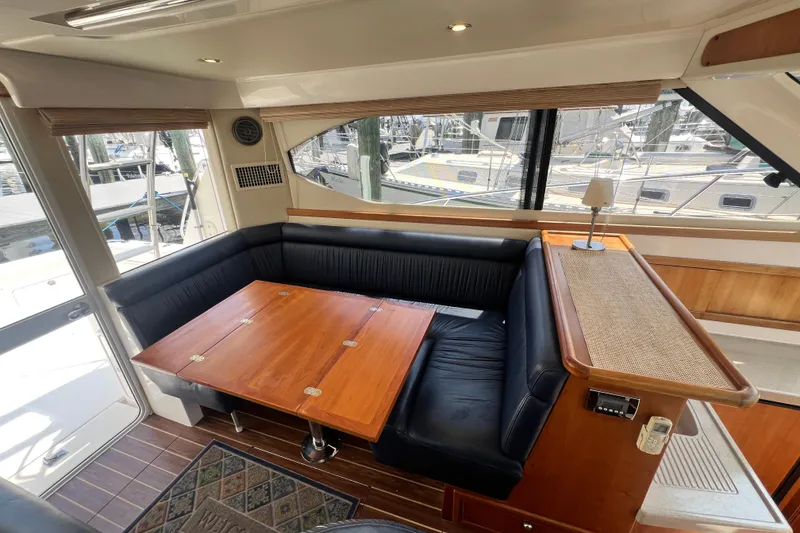Slide: The Image of Interior of 2007 Riviera 33 Flybridge yacht with elegant seating and wooden table. - 35