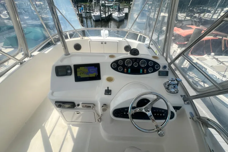 Slide: The Image of 2007 Riviera 33 Flybridge helm with navigation equipment and marina view. - 39