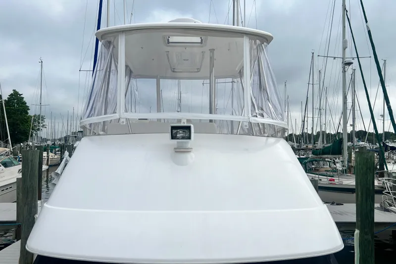 Slide: The Image of 2007 Riviera 33 Flybridge yacht docked at a marina, surrounded by sailboats. - 48