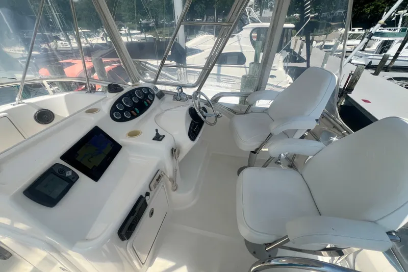 Slide: The Image of 2007 Riviera 33 Flybridge helm with dual seats, navigation controls, and clear view of marina. - 40