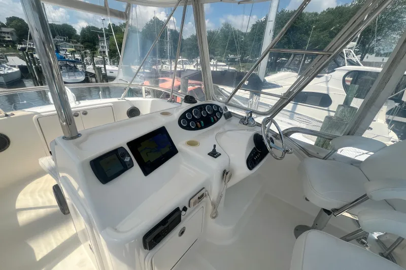 Slide: The Image of 2007 Riviera 33 Flybridge yacht helm with navigation controls and seating. - 41