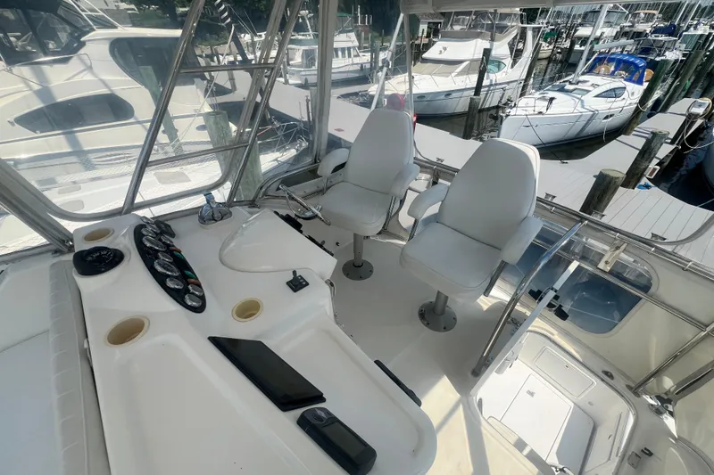 Slide: The Image of Flybridge of 2007 Riviera 33 yacht with helm controls and seating at marina. - 42