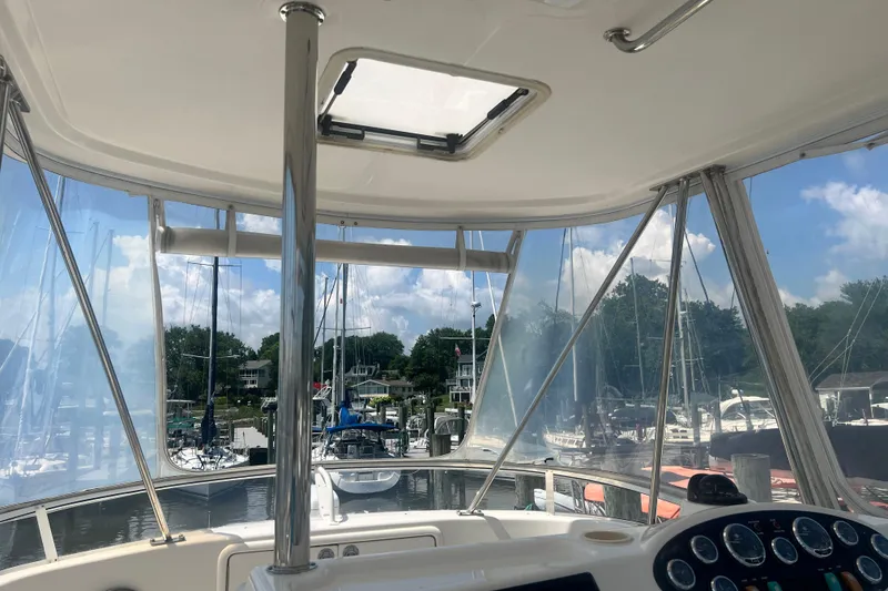 Slide: The Image of Interior view of 2007 Riviera 33 Flybridge yacht at marina, showcasing helm and clear skies. - 44