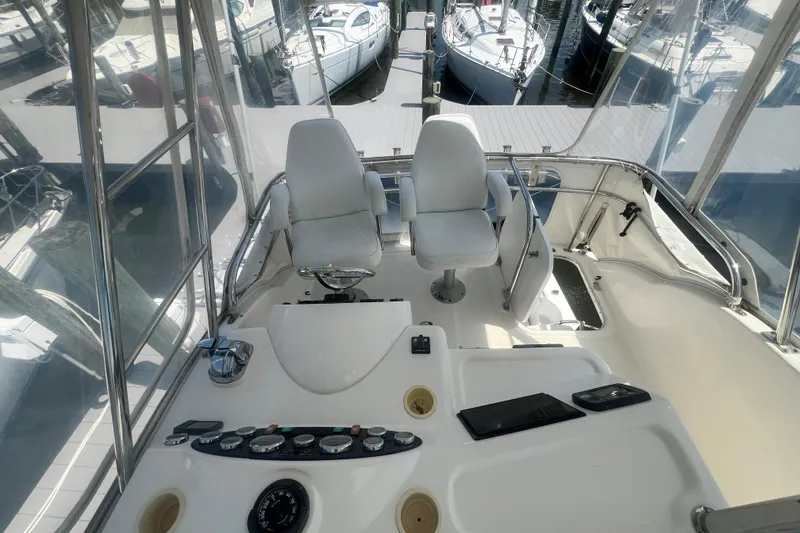 Slide: The Image of Flybridge of 2007 Riviera 33 yacht with dual white captain chairs and control panel. - 49