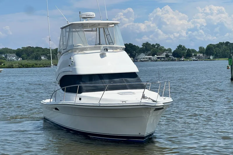 Slide: The Image of 2007 Riviera 33 Flybridge yacht on calm water with scenic background. - 5