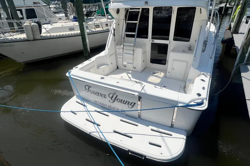 Slide: The Image of 2007 Riviera 33 Flybridge yacht docked, named "Forever Young," at Bethany Beach marina. - 57