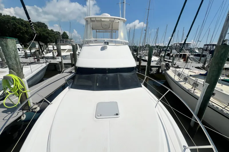 Slide: The Image of 2007 Riviera 33 Flybridge yacht docked at marina under clear blue sky. - 59