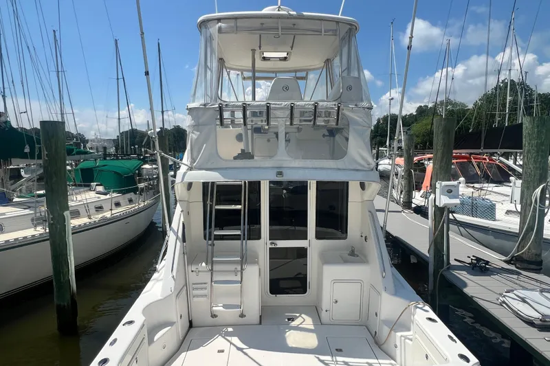 Slide: The Image of 2007 Riviera 33 Flybridge yacht docked at marina under clear blue sky. - 60