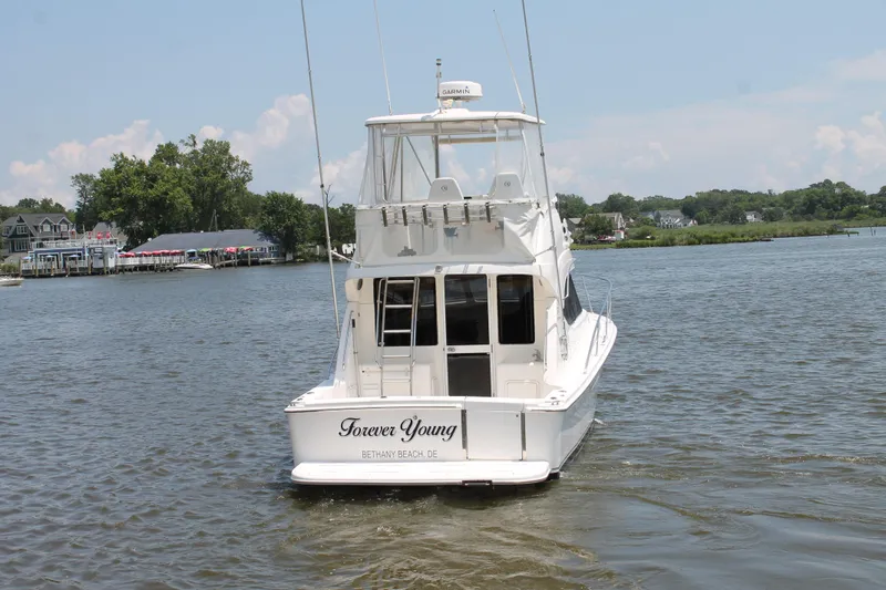Slide: The Image of 2007 Riviera 33 Flybridge yacht on water, rear view, with scenic background. - 7