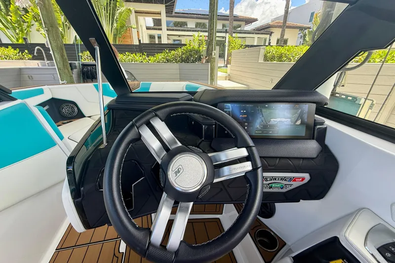 Slide: The Image of 2024 Nautique Super Air Nautique GS20 dashboard with steering wheel and touchscreen display. - 14