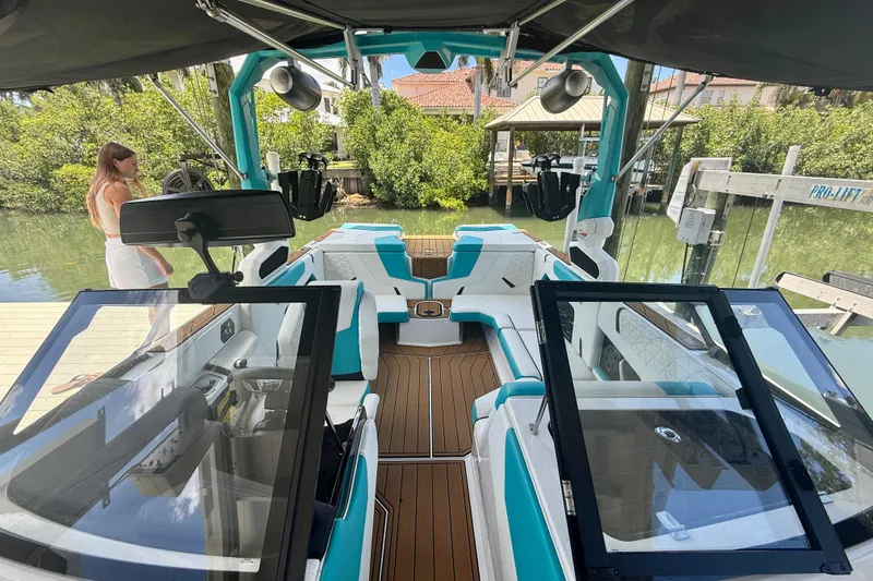 Slide: The Image of 2024 Nautique Super Air Nautique GS20 boat interior with teal and white seating. - 18