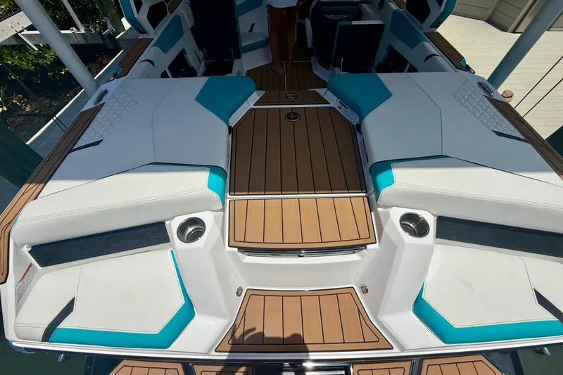 Slide: The Image of 2024 Nautique Super Air Nautique GS20 boat interior with teak flooring and white seating. - 20