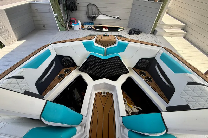 Slide: The Image of 2024 Nautique Super Air Nautique GS20 boat interior with teal and white seating. - 33
