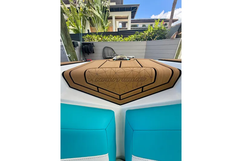 Slide: The Image of 2024 Nautique Super Air Nautique GS20 boat interior with teal and tan upholstery. - 8