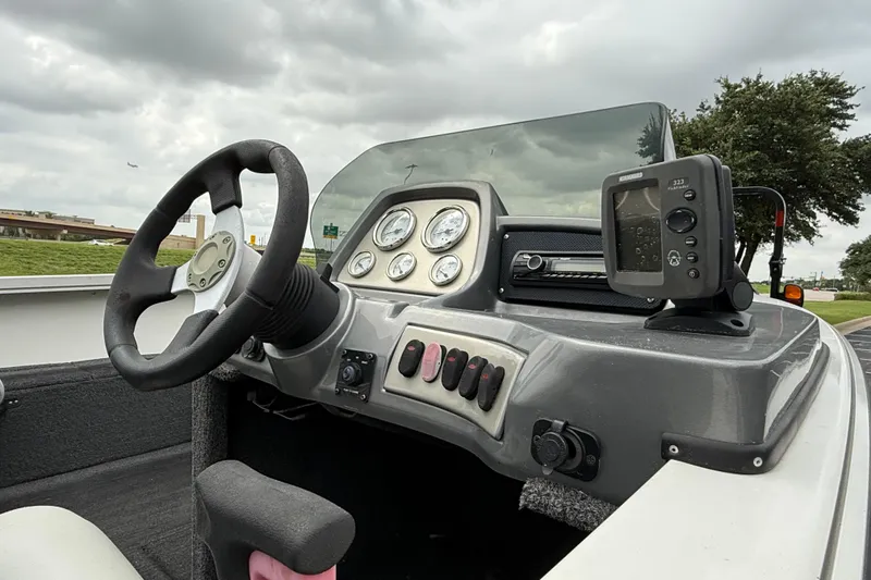 Slide: The Image of 2011 Lowe Fishing Machine 175 dashboard with steering wheel and fish finder. - 4