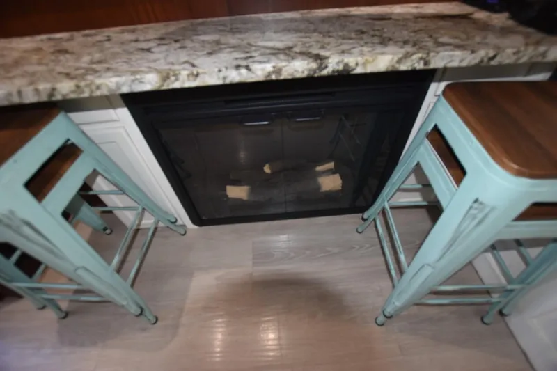 Slide: The Image of Granite countertop with teal bar stools and a fireplace on a Hatteras 50 Convertible yacht. - 13