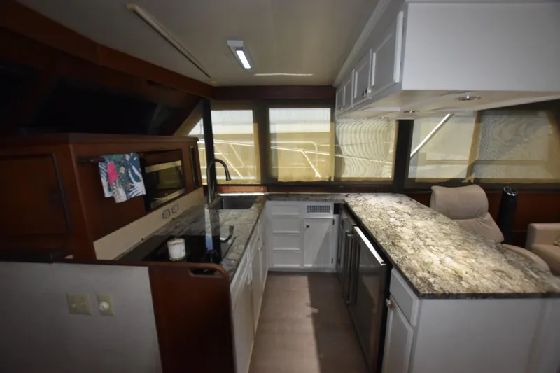 Slide: The Image of Interior of 1983 Hatteras 50 Convertible yacht with modern kitchen and granite countertops. - 14