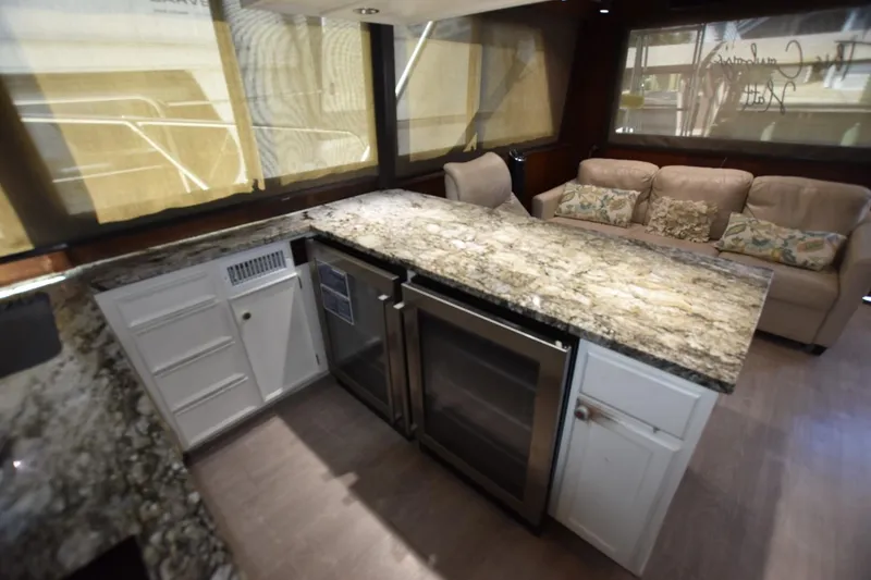 Slide: The Image of Luxurious interior of 1983 Hatteras 50 Convertible yacht with granite countertops and plush seating. - 16