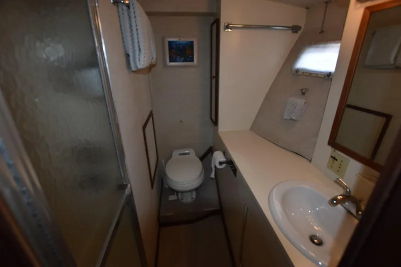 Slide: The Image of Bathroom interior of 1983 Hatteras 50 Convertible yacht, featuring sink, toilet, and shower. - 18