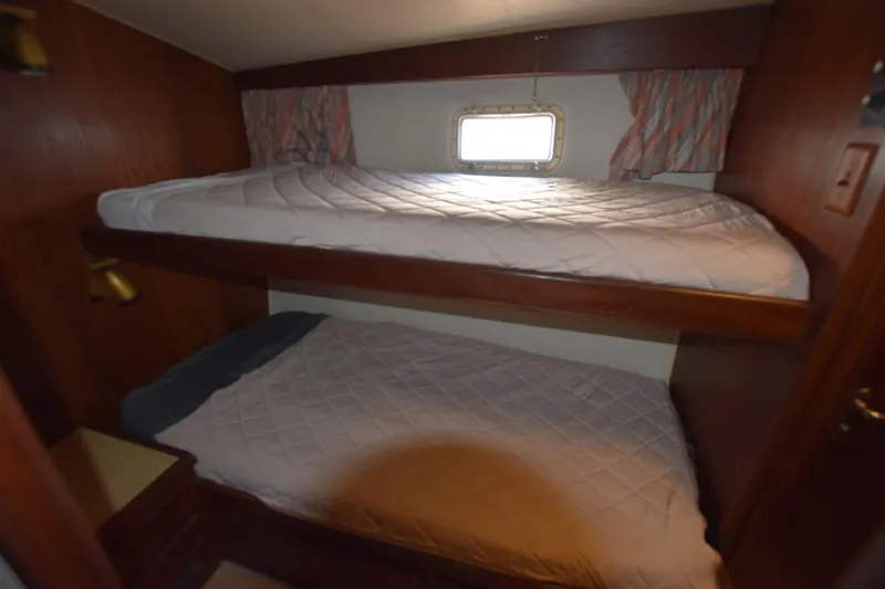 Slide: The Image of Bunk beds in 1983 Hatteras 50 Convertible yacht cabin with window and curtains. - 19