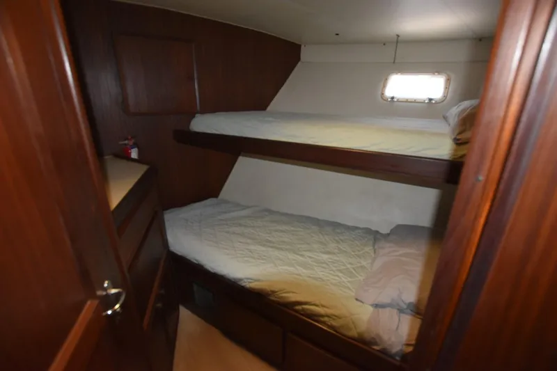 Slide: The Image of Interior cabin of 1983 Hatteras 50 Convertible yacht with bunk beds and wooden finish. - 22