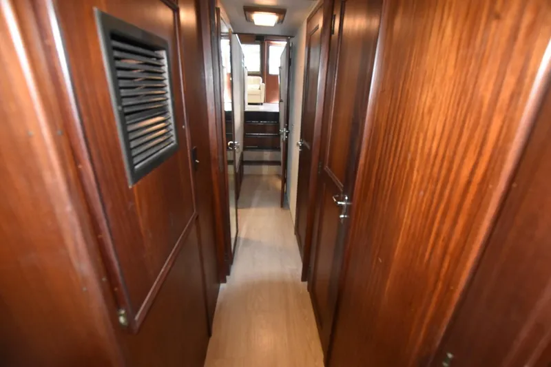 Slide: The Image of Interior hallway of 1983 Hatteras 50 Convertible yacht with wooden paneling and doors. - 23