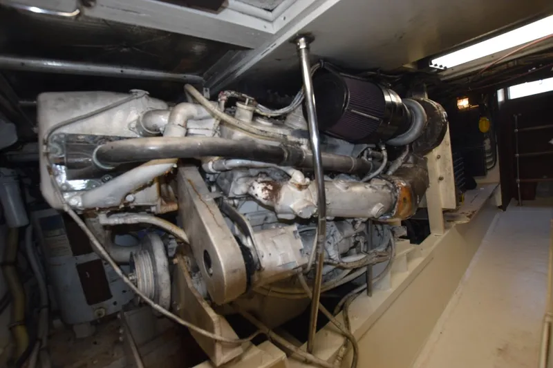 Slide: The Image of Engine room of a 1983 Hatteras 50 Convertible yacht, showcasing mechanical components. - 25
