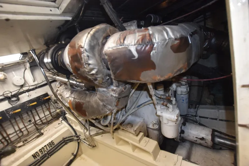 Slide: The Image of Engine room of 1983 Hatteras 50 Convertible yacht with insulated components and wiring. - 26