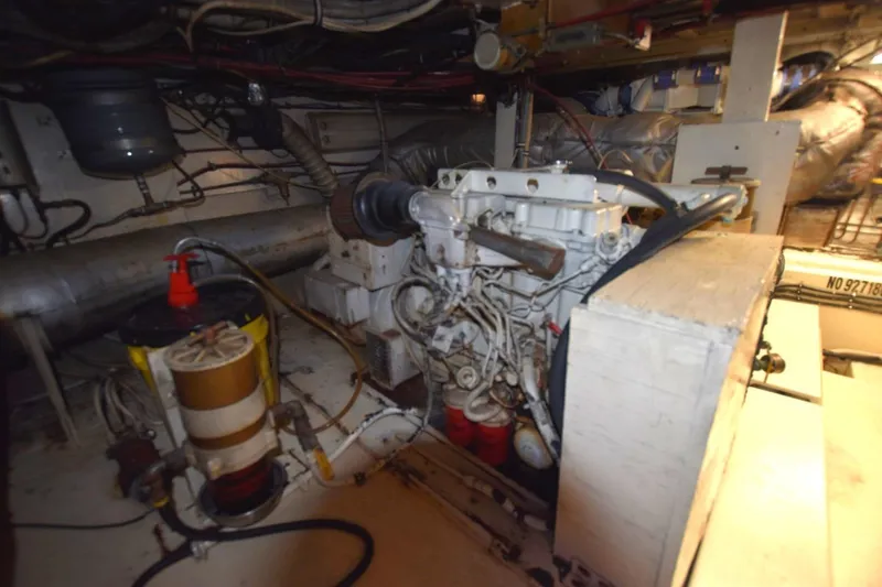 Slide: The Image of Engine room of 1983 Hatteras 50 Convertible yacht, showcasing mechanical components and wiring. - 29