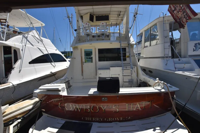Slide: The Image of 1983 Hatteras 50 Convertible yacht docked, rear view with ladder and deck. - 3