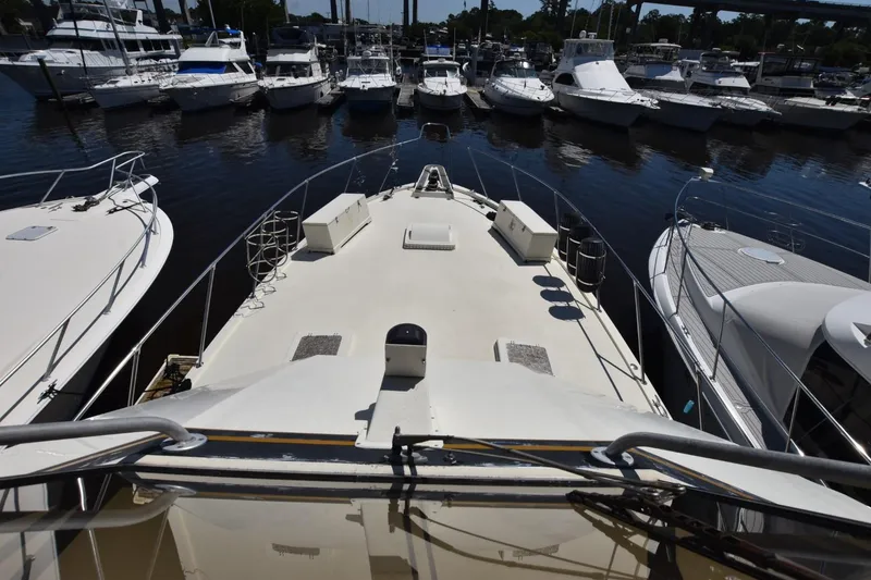 Slide: The Image of 1983 Hatteras 50 Convertible yacht docked among other boats in a marina. - 4