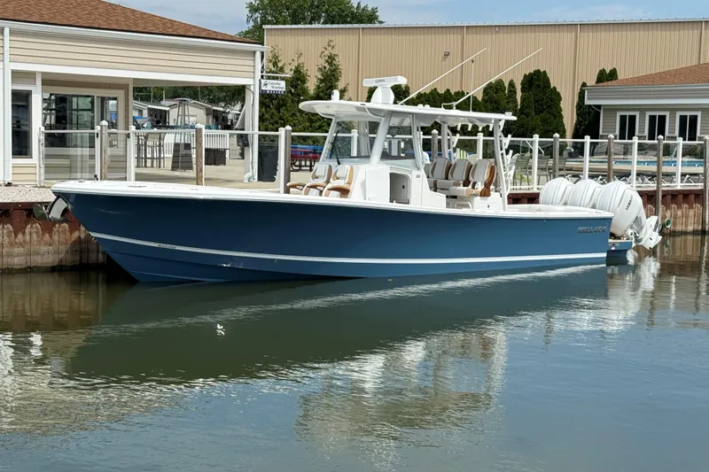 Slide: The Image of 2027 Regulator 35 boat docked, featuring sleek blue design and powerful engines. - 14