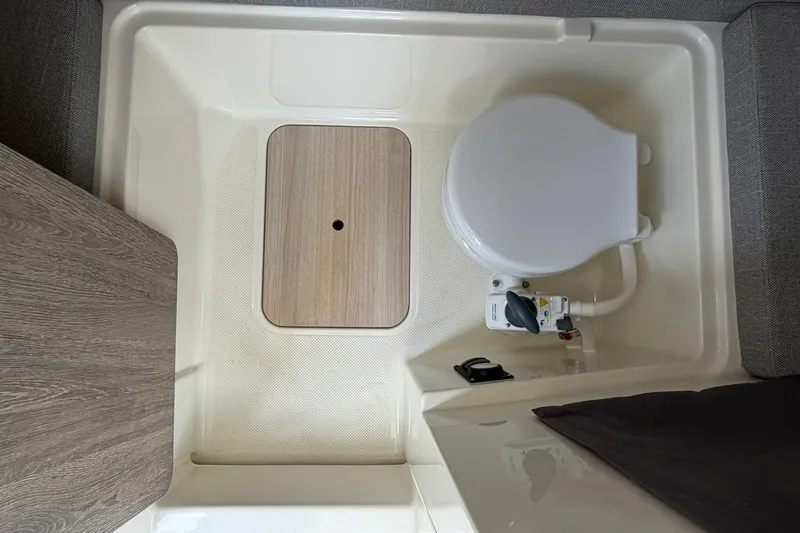 Slide: The Image of 2025 Bayliner Trophy T23 Pilothouse interior with compact marine toilet setup. - 34
