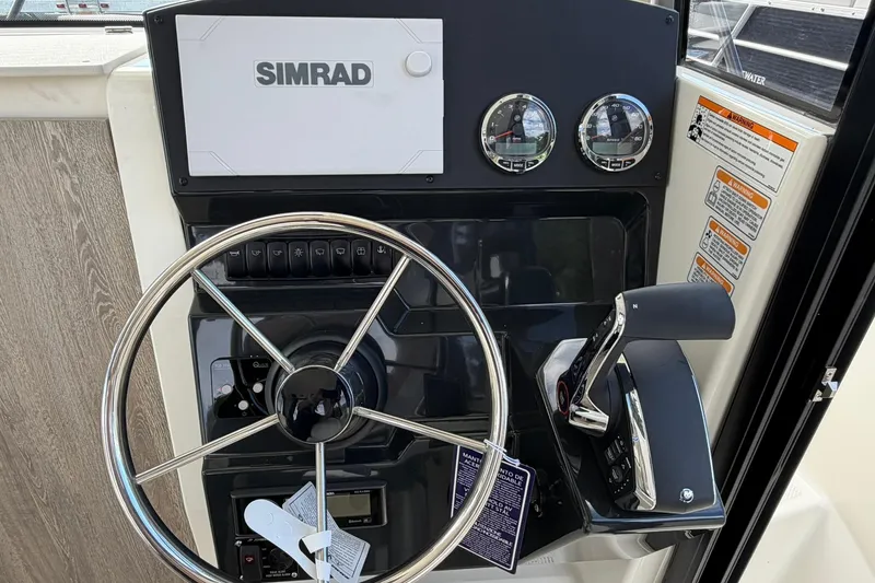 Slide: The Image of 2025 Bayliner Trophy T23 Pilothouse helm with Simrad display and controls. - 23