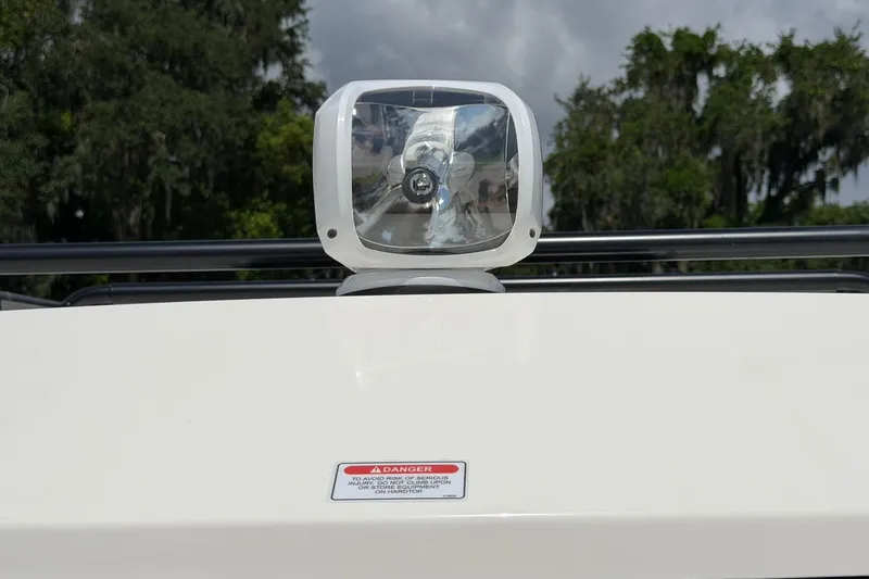 Slide: The Image of 2025 Bayliner Trophy T23 Pilothouse spotlight with warning label, set against a natural backdrop. - 7