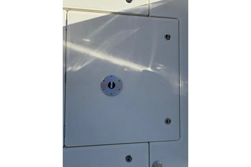 Slide: The Image of Bayliner Trophy T23 Pilothouse 2025 boat compartment with secure latch and textured surface. - 41