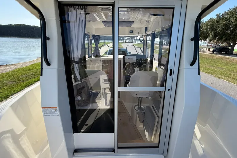 Slide: The Image of 2025 Bayliner Trophy T23 Pilothouse interior view with steering wheel and seating. - 14