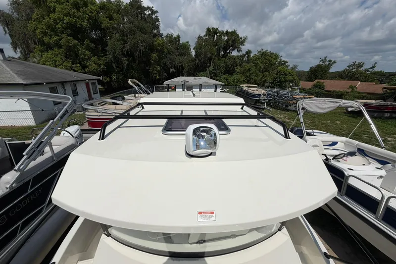Slide: The Image of 2025 Bayliner Trophy T23 Pilothouse boat on display, surrounded by other boats. - 6