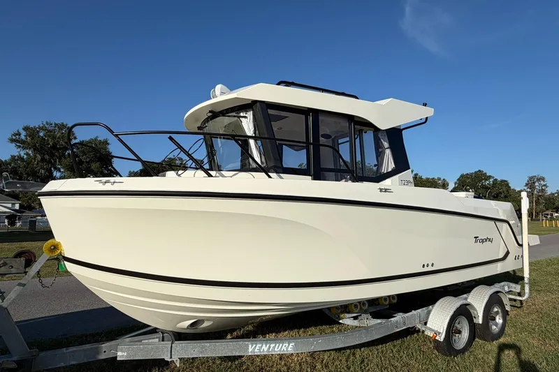 Slide: The Image of 2025 Bayliner Trophy T23 Pilothouse boat on trailer under clear blue sky. - 65