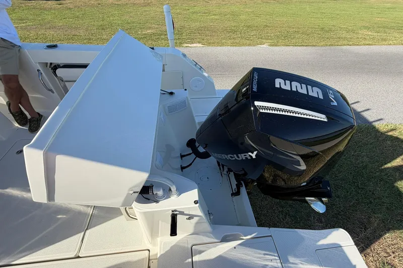 Slide: The Image of 2025 Bayliner Trophy T23 Pilothouse with Mercury outboard engine, docked on grass. - 56