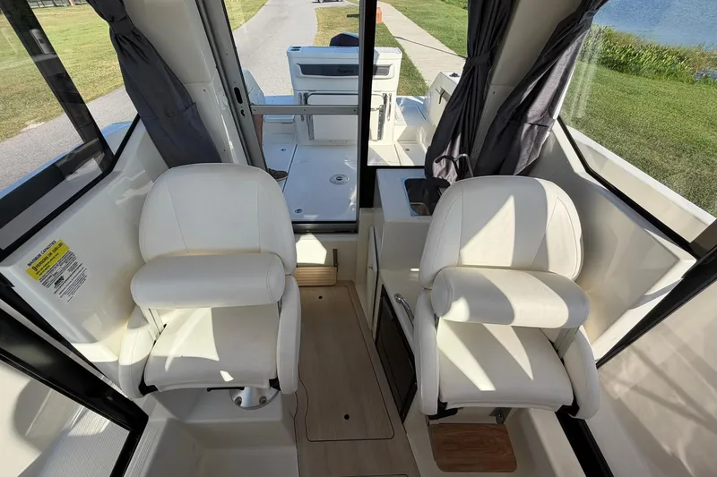 Slide: The Image of Interior of 2025 Bayliner Trophy T23 Pilothouse with two white captain chairs. - 36