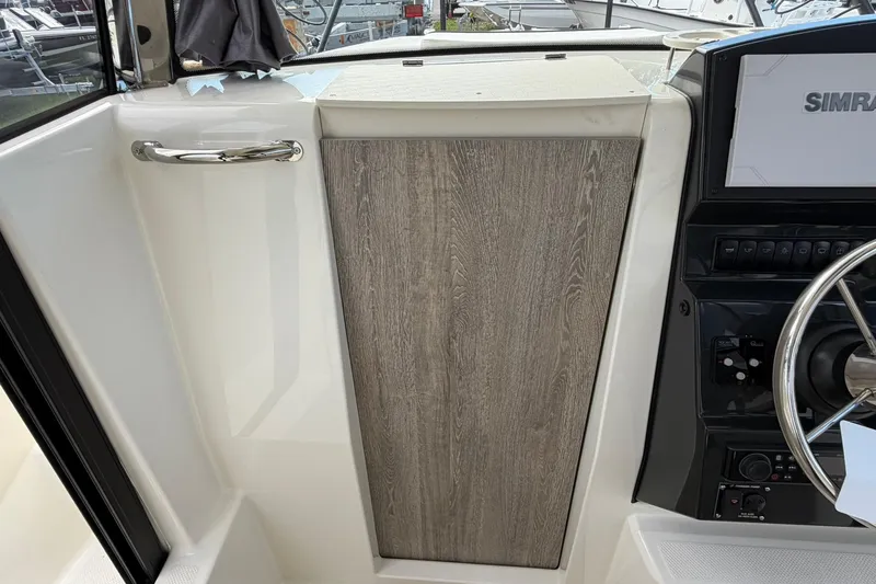 Slide: The Image of 2025 Bayliner Trophy T23 Pilothouse interior with steering wheel and control panel. - 29