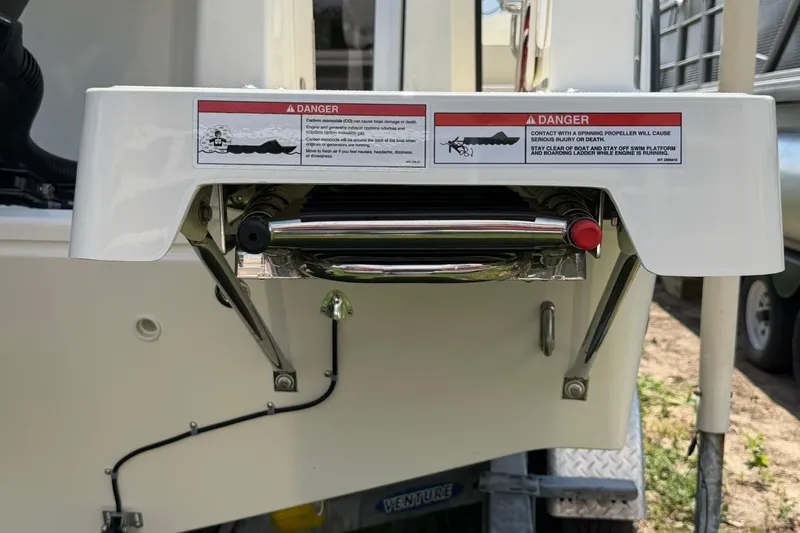 Slide: The Image of 2025 Bayliner Trophy T23 Pilothouse swim platform with safety warnings and ladder. - 58