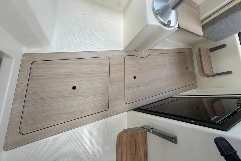 Slide: The Image of 2025 Bayliner Trophy T23 Pilothouse interior with wood finish and storage compartments. - 37