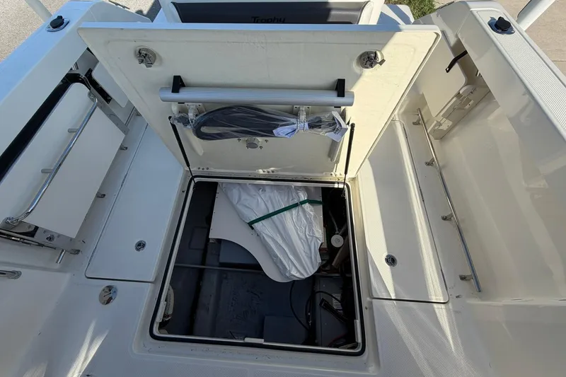 Slide: The Image of 2025 Bayliner Trophy T23 Pilothouse storage compartment with open hatch, showcasing interior details. - 42