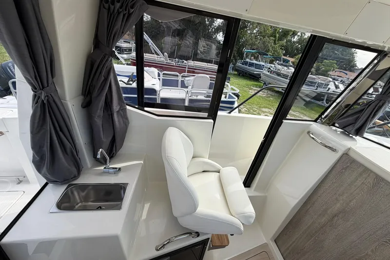 Slide: The Image of Interior of 2025 Bayliner Trophy T23 Pilothouse with sink, chair, and window view. - 21