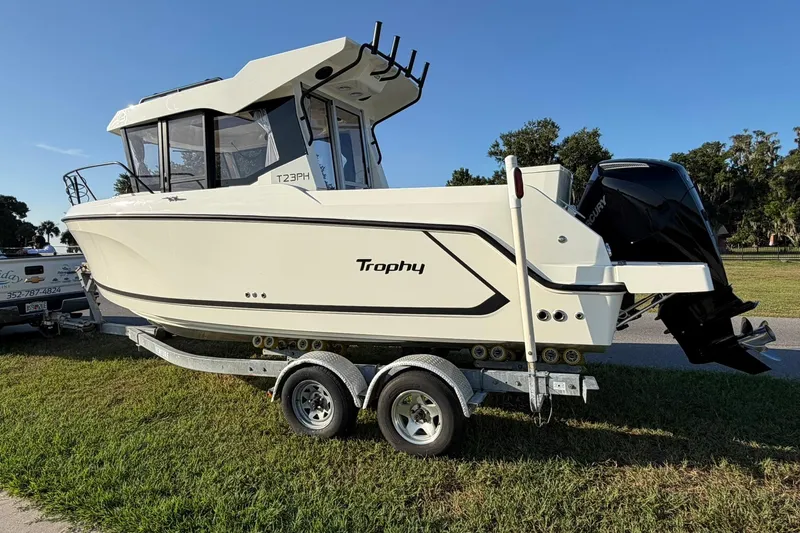 Slide: The Image of 2025 Bayliner Trophy T23 Pilothouse boat on trailer, side view, outdoors. - 64